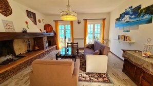 A cozy living room with a fireplace, a sofa, a coffee table, and a chandelier. - Country House Casa Marisa Balcony lake view (Tremosine)