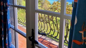 A room with a large window offering a view of a mountainous landscape and a lake. - Country House Casa Marisa Balcony lake view (Tremosine)