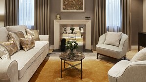 A living room with a sofa, armchair, and a small table with a vase. - Cheval Hyde Park Gate (London)