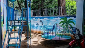 A beach-themed mural with a lifeguard tower, a slide, and a motorcycle. - Lux Suites Micasa Sandalwood Apartments (Nairobi)