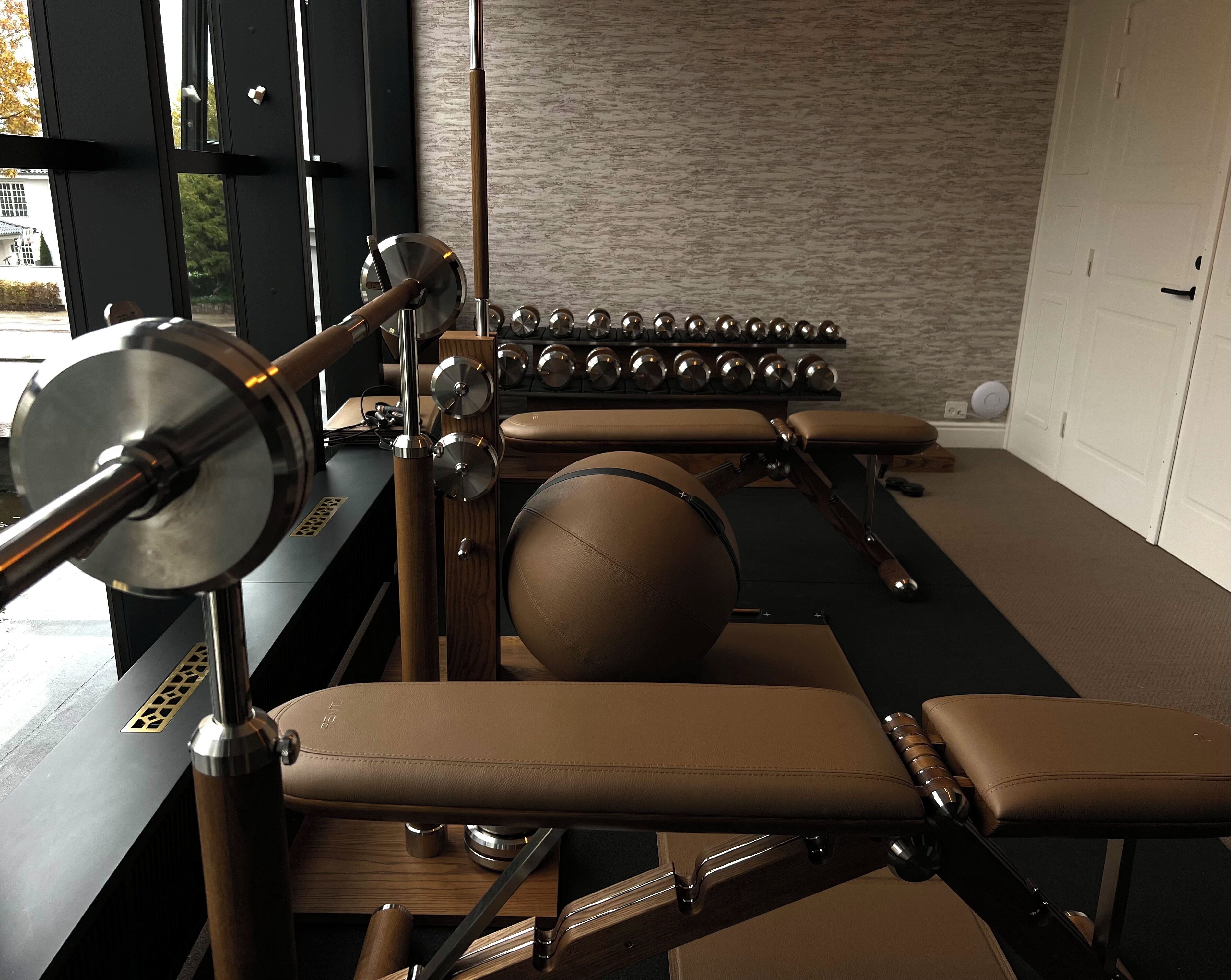 Ett gym med träningsutrustning, inklusive en roddmaskin och hantlar.