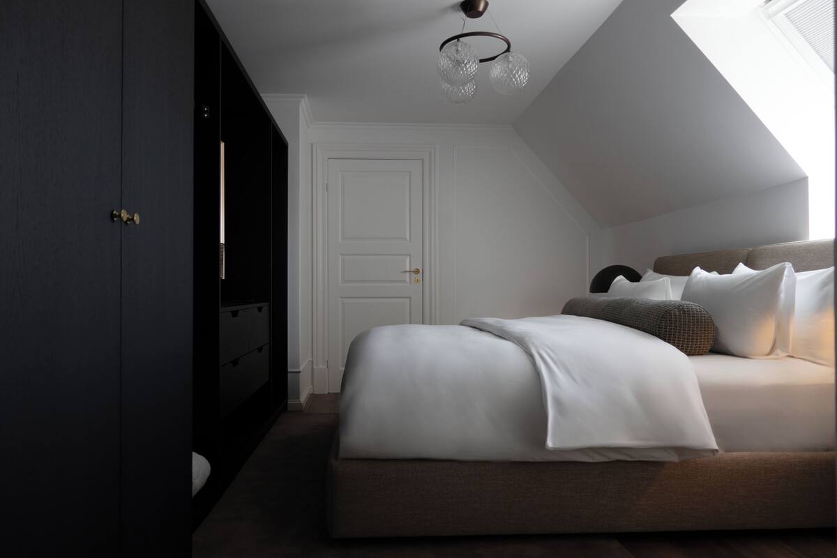 Un dormitorio con una cama grande, un armario y un tragaluz.