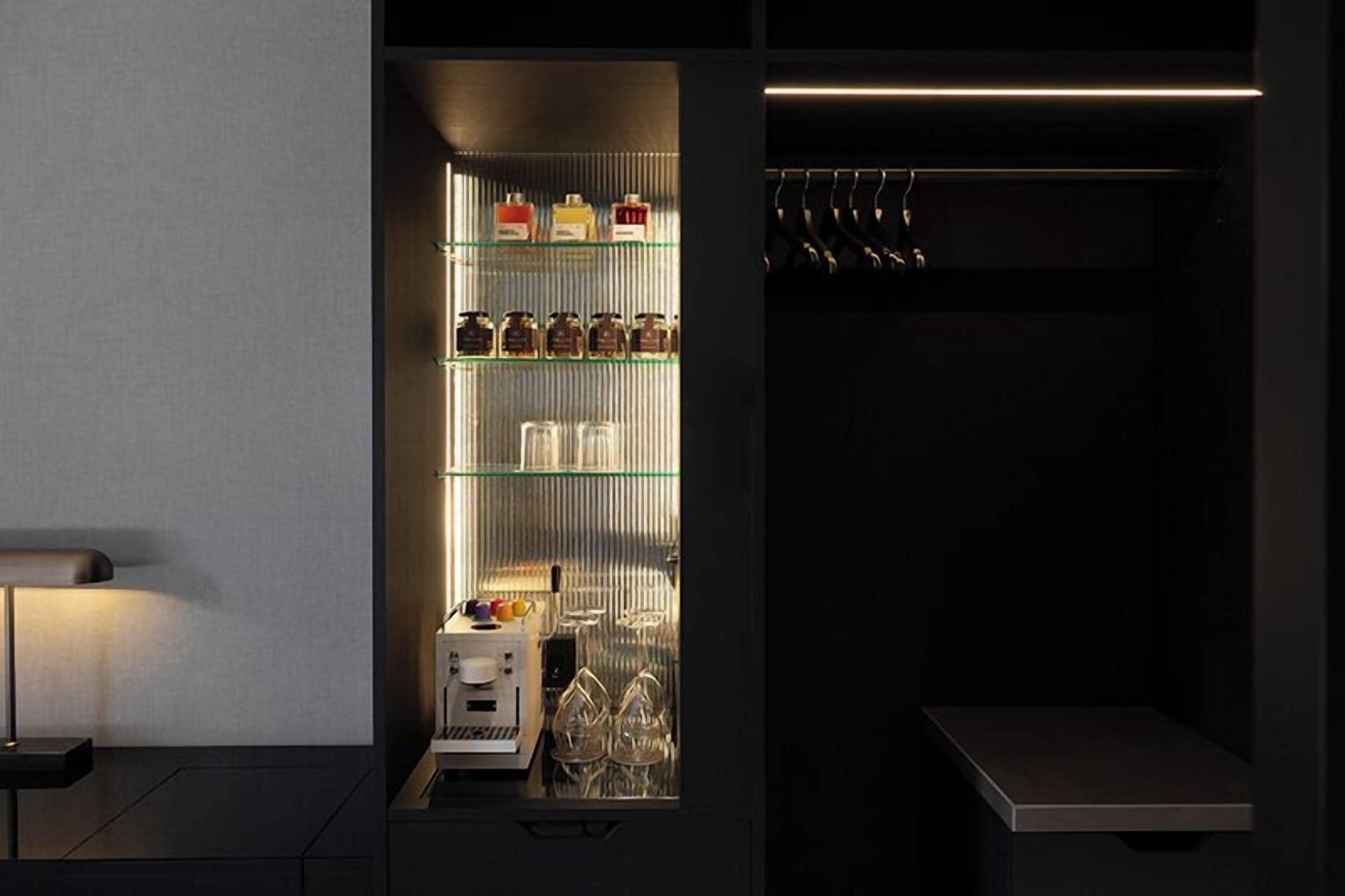 A modern kitchen with a built-in refrigerator, a coffee machine, and a hanging rack for utensils.