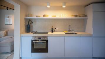 A compact kitchen with a built-in oven, a sink, and a countertop.