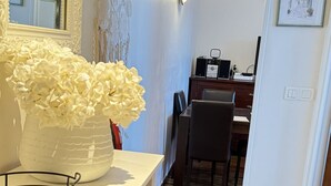 A modern dining area with a white table, chairs, and a red rug.
