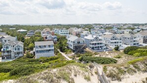 Ein Küstenwohngebiet mit Häusern, die Balkone und einen Zugang zum Strand haben.