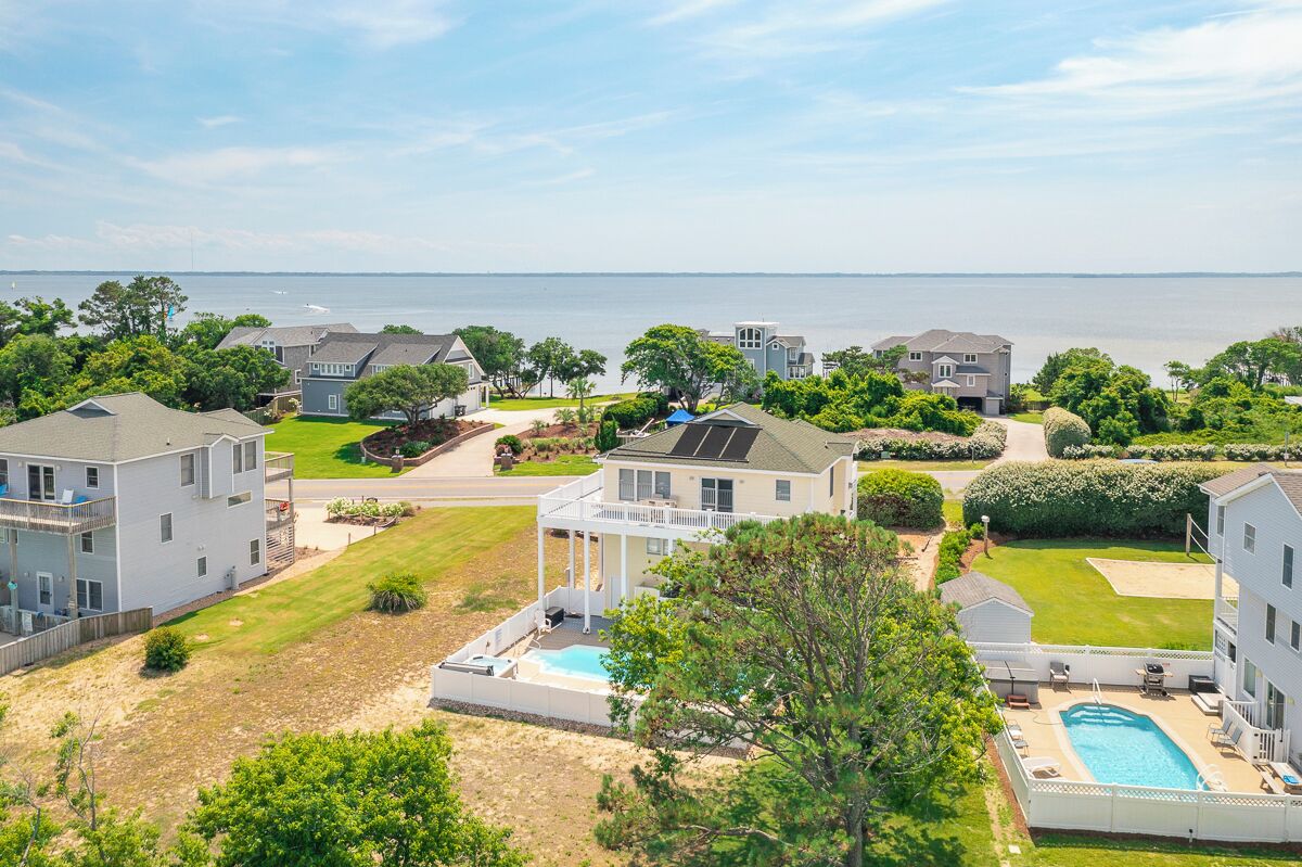 A residential area with houses, a swimming pool, and a view of the water.