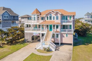 A multi-story house with a central staircase, a balcony, and a front porch.