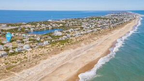 Une ville côtière dotée de propriétés en bord de mer, d’un port de plaisance et offrant une vue dégagée sur l’océan.