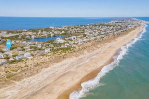 A coastal town with beachfront properties, a marina, and a clear view of the ocean.