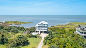 A coastal property with a large two-story house featuring a balcony, a pool, and a pier extending into the water. - Soundfront serenity with a private dock at Blue Horizon in Salvo! (Salvo)