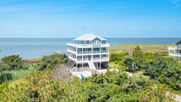 A multi-story beachfront property with a large balcony, a pool, and a view of the ocean. - Soundfront serenity with a private dock at Blue Horizon in Salvo! (Salvo)