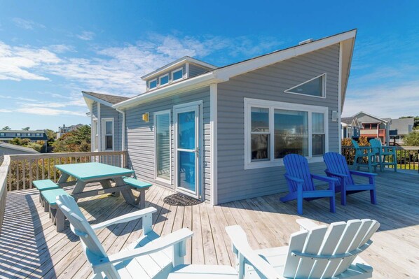 A deck with a small building, outdoor seating, and a view of the surrounding area.