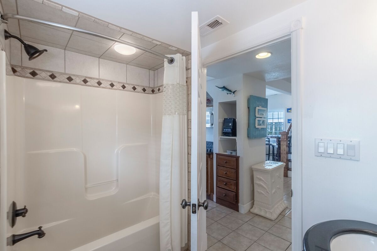 A bathroom with a shower, toilet, and a sink.