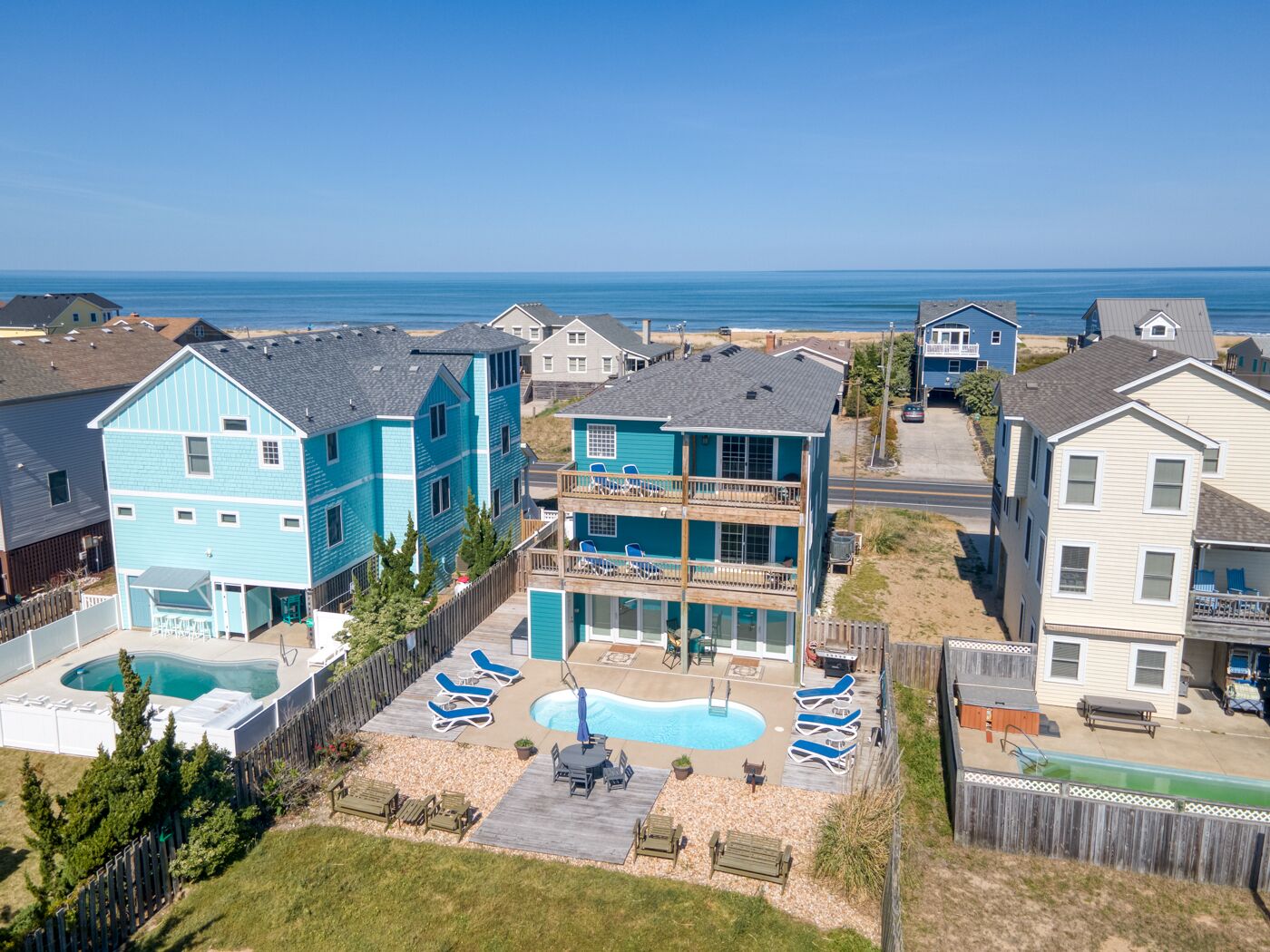 A residential area with a large house featuring a swimming pool and multiple balconies.
