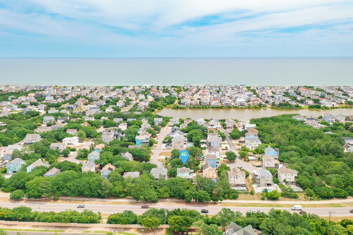 A coastal residential area with houses, a lake, and a road.