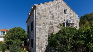 Un edificio in pietra con una piccola finestra e un condizionatore d'aria.