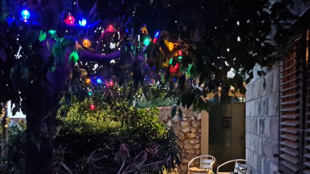 Un'area patio con un muro in pietra, due sedie in metallo e un tavolo.