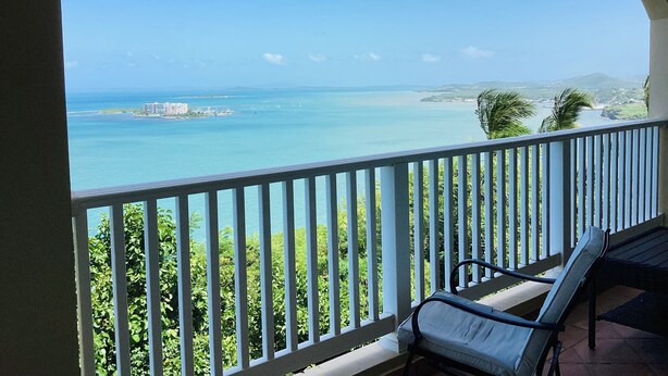 Ein Balkon mit Blick auf das Meer und eine entfernte Insel.