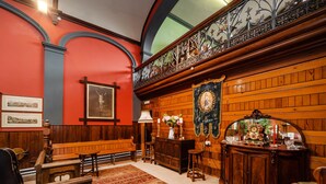 A room with wooden paneling, a bench, a table, and a decorative mirror. - The Old Sunday School & Vestry (Cromer)