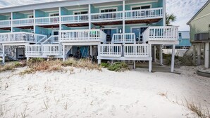A beachfront building with multiple balconies and a sandy beach in front. - Boardwalk D6 (Pensacola Beach)