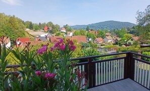 Ein Wohngebiet mit Häusern, einer Holzterrasse und einem Berg im Hintergrund.
