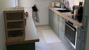 A compact kitchen with a built-in oven, a sink, and a window. - Apartment with swimming pool - near train station (Villers-sur-Mer)