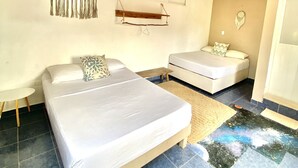 A room with two beds, a ceiling fan, a wall-mounted air conditioner, and a small shelf. - Barco Verde Hostel  (Isla Holbox)