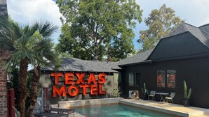 Een zwembadgedeelte met een bord waarop 'Texas Motel' staat.