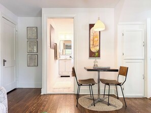 A dining area with a table, chairs, and a pendant light.