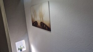 En trappa med en vägg som har en intressant yta och en inramad tavla.