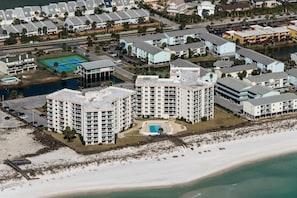 Ein Küstenhotel mit mehreren Hochhäusern, einem Strand und einem Tennisplatz.