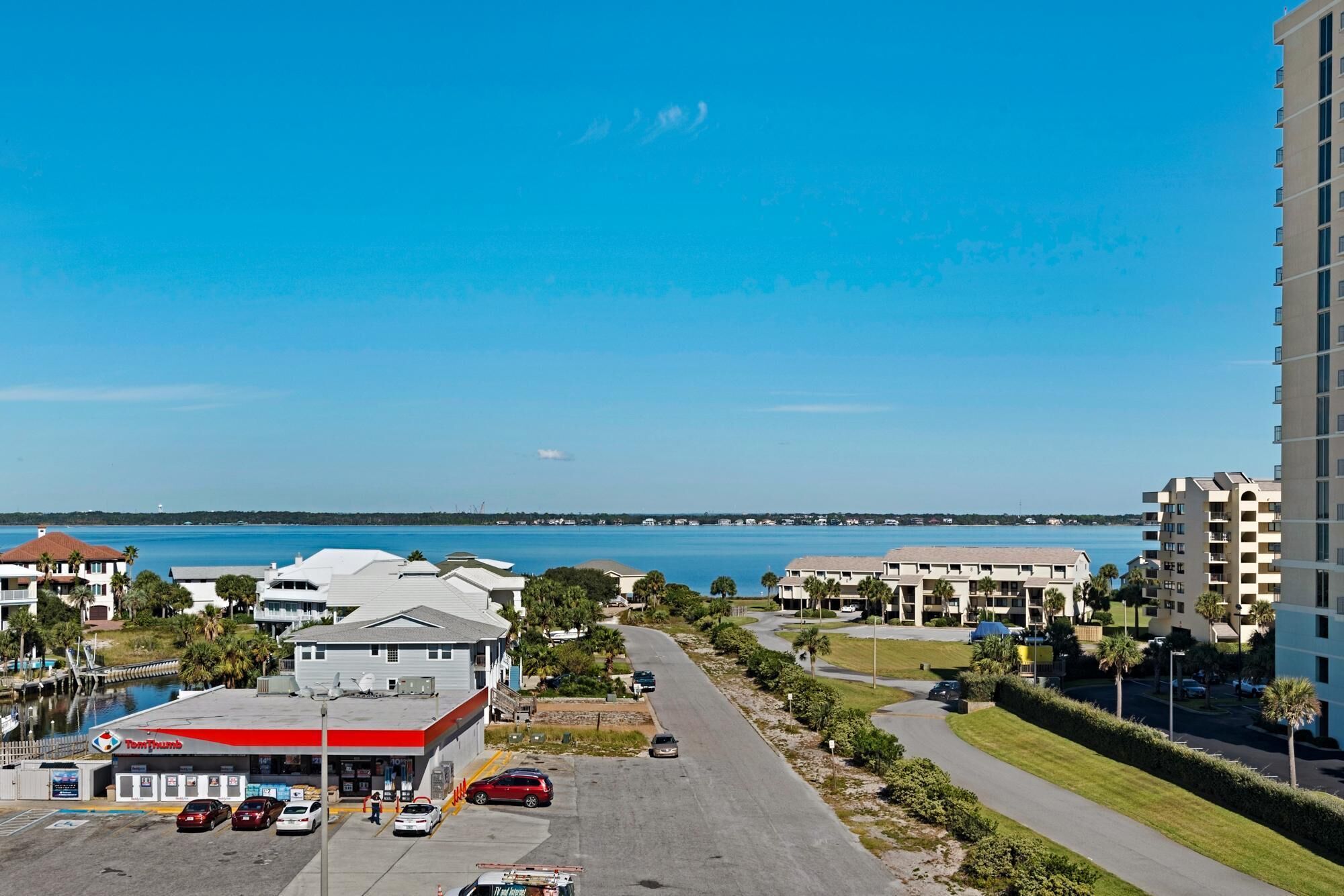 A coastal view with a marina, a Tom Thumb gas station, and residential buildings.