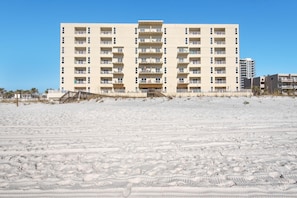 A multi-story hotel with balconies, located on a sandy beach. - Sans Souci Unit 307 (Pensacola Beach)