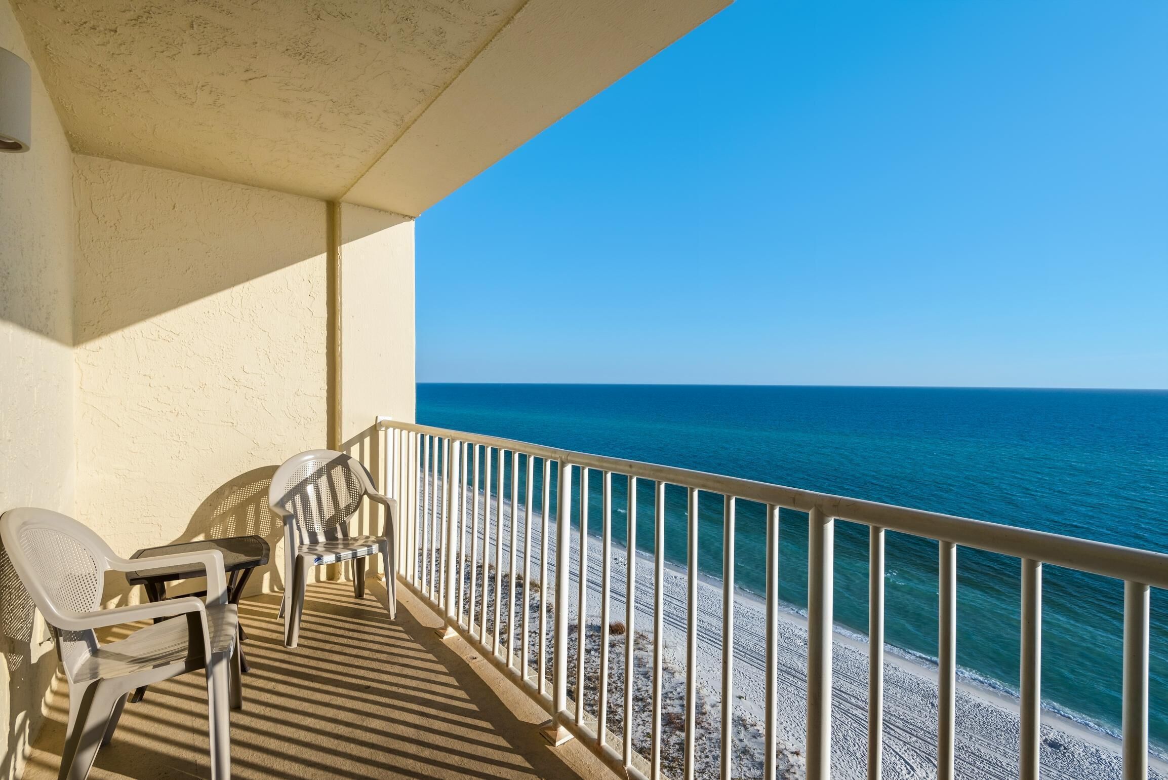 Ein Balkon mit Blick auf Strand und Meer.