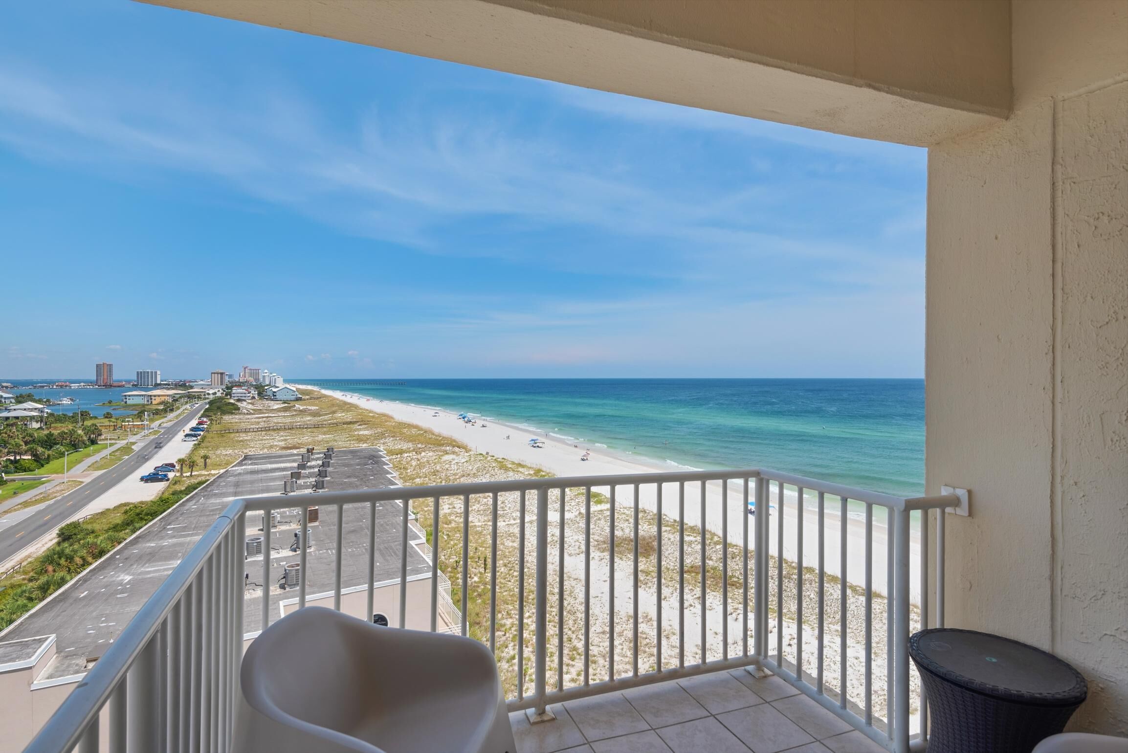 Ein Balkon mit Blick auf Strand und Meer.