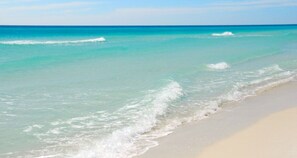 Una playa con agua turquesa cristalina y olas suaves.