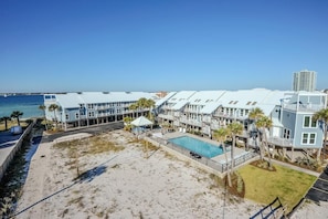 A beachfront hotel with multiple-story buildings, a swimming pool, and a view of the ocean. - Labahia 128 (Pensacola Beach)