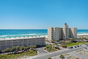 A coastal hotel with multiple floors, a parking area, and a view of the ocean. - Seahorse Unit M (Pensacola Beach)