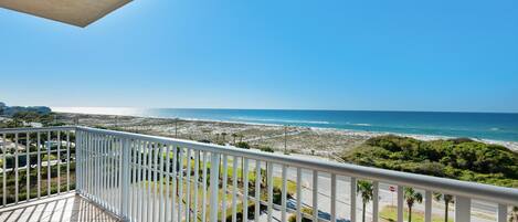 A balcony with a view of the beach and ocean.