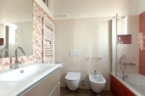 A modern bathroom with a large bathtub, a separate shower area, a bidet, and a toilet. - Lo Spole Apartment by BarbarHouse (Milano)