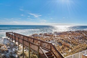 A wooden boardwalk leading to a beach with sand dunes and a clear blue sky. - Starboard Village 424- Beach Haven (Pensacola Beach)