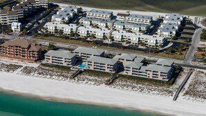 Un hôtel situé sur la côte, composé de plusieurs bâtiments, avec une plage et une jetée.