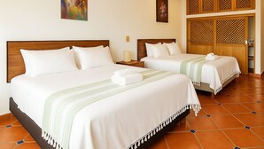 Una habitación de hotel con dos camas, un ventilador de techo y un panel decorativo de madera en la pared.
