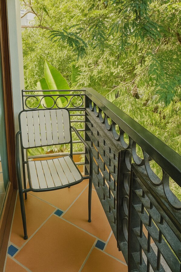 Ein Balkon mit Metallgeländer und einem weißen Stuhl.