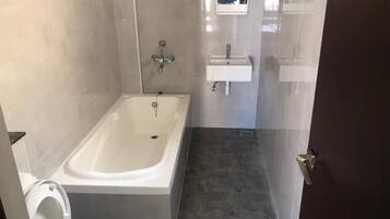 Un bagno con una vasca, un water e un lavandino.
