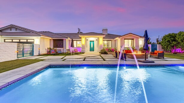 A residential property with a swimming pool, outdoor seating, and a well-lit entrance. - Rising Sun House: Pool, Spa, GameRoom, PetFriendly! (Palm Springs)