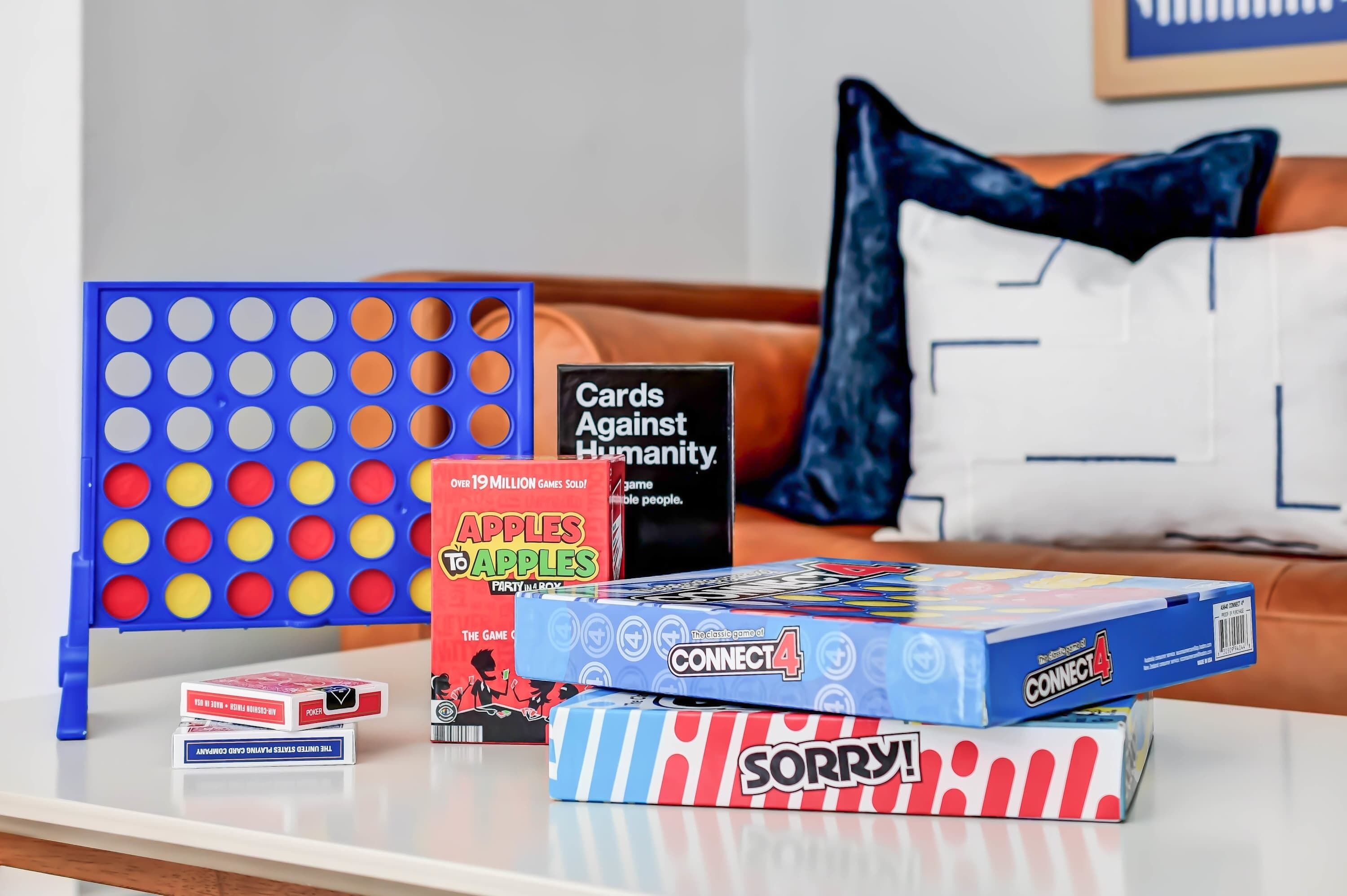 A table with various board games and a Connect4 game box.