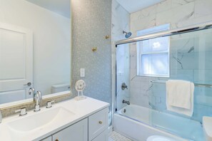 A bathroom with a large mirror, a white sink, a glass-enclosed shower, and a white towel. - Lincoln Lofts: 201 | 2BR Sunlit Designer Retreat (Washington)