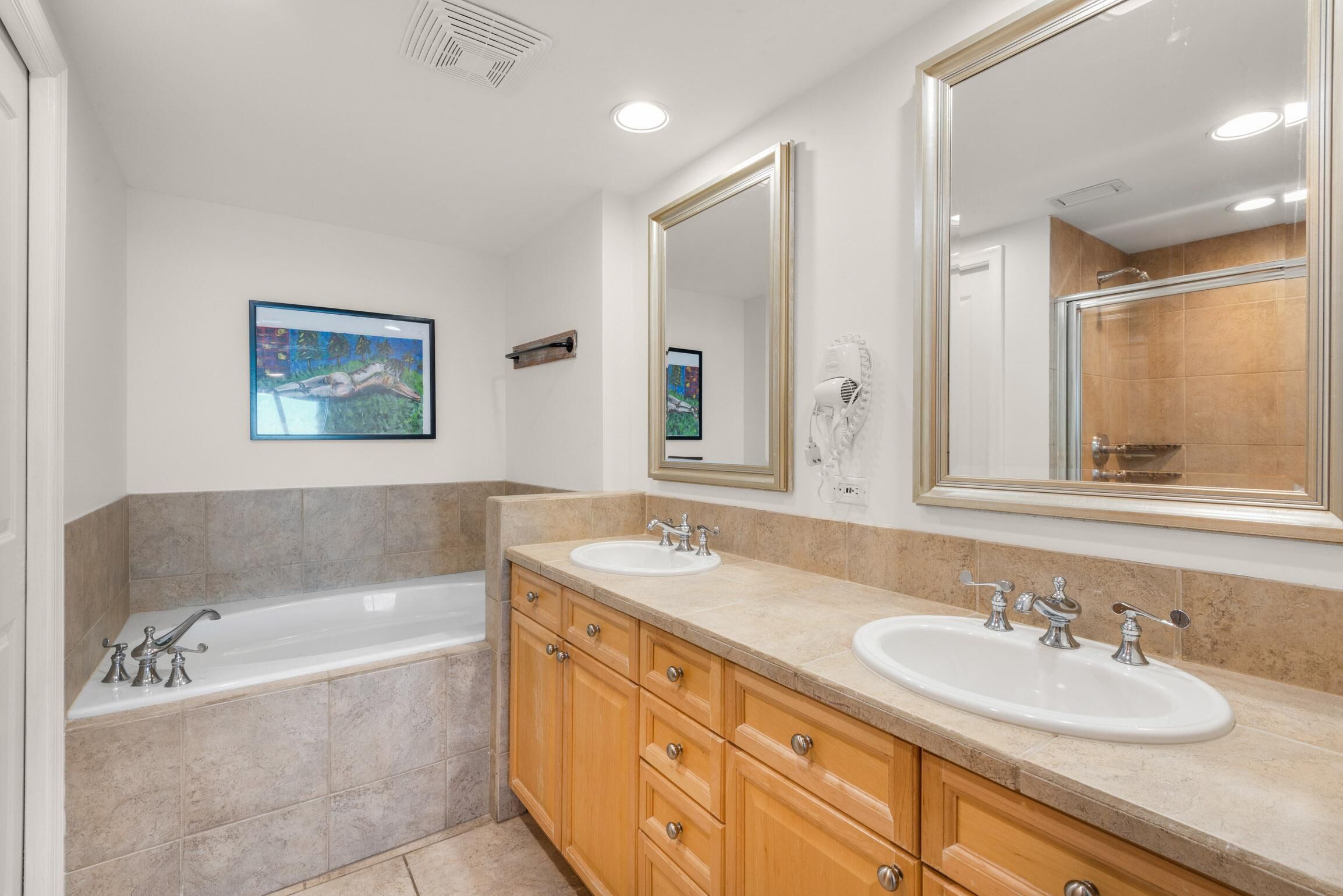 Un baño moderno con tocador doble, un espejo grande y una bañera.